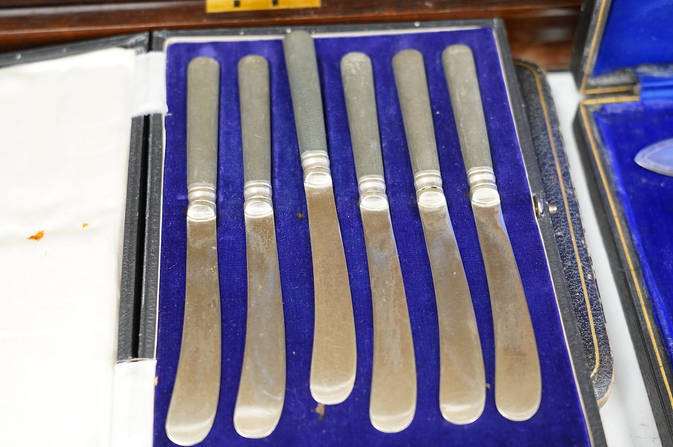 A cased set of six silver handled tea knives and six other cased plated sets. Condition - fair